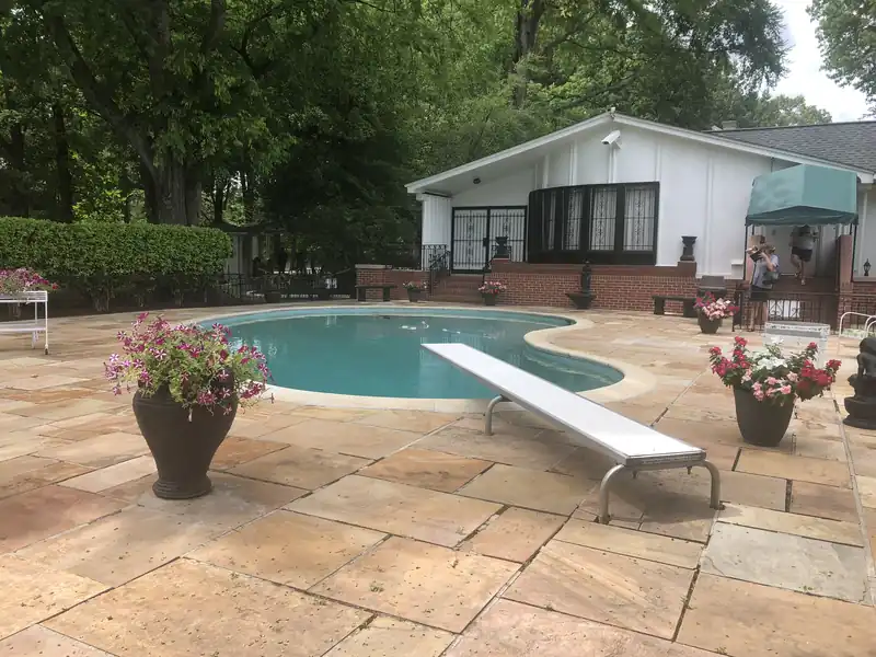 Poured concrete patio and pool deck behind a single-story home