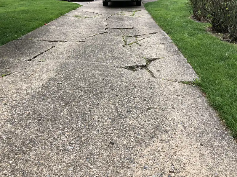 Old concrete driveway with cracked and sunken panels